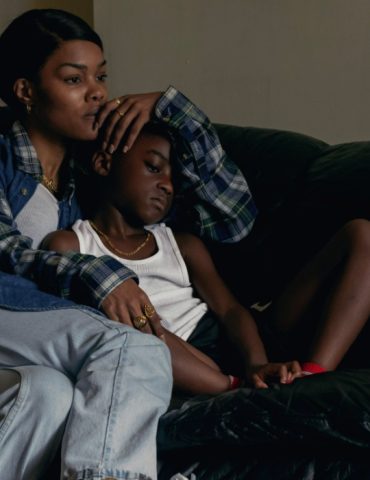 A woman and a little girl are seated on the couch